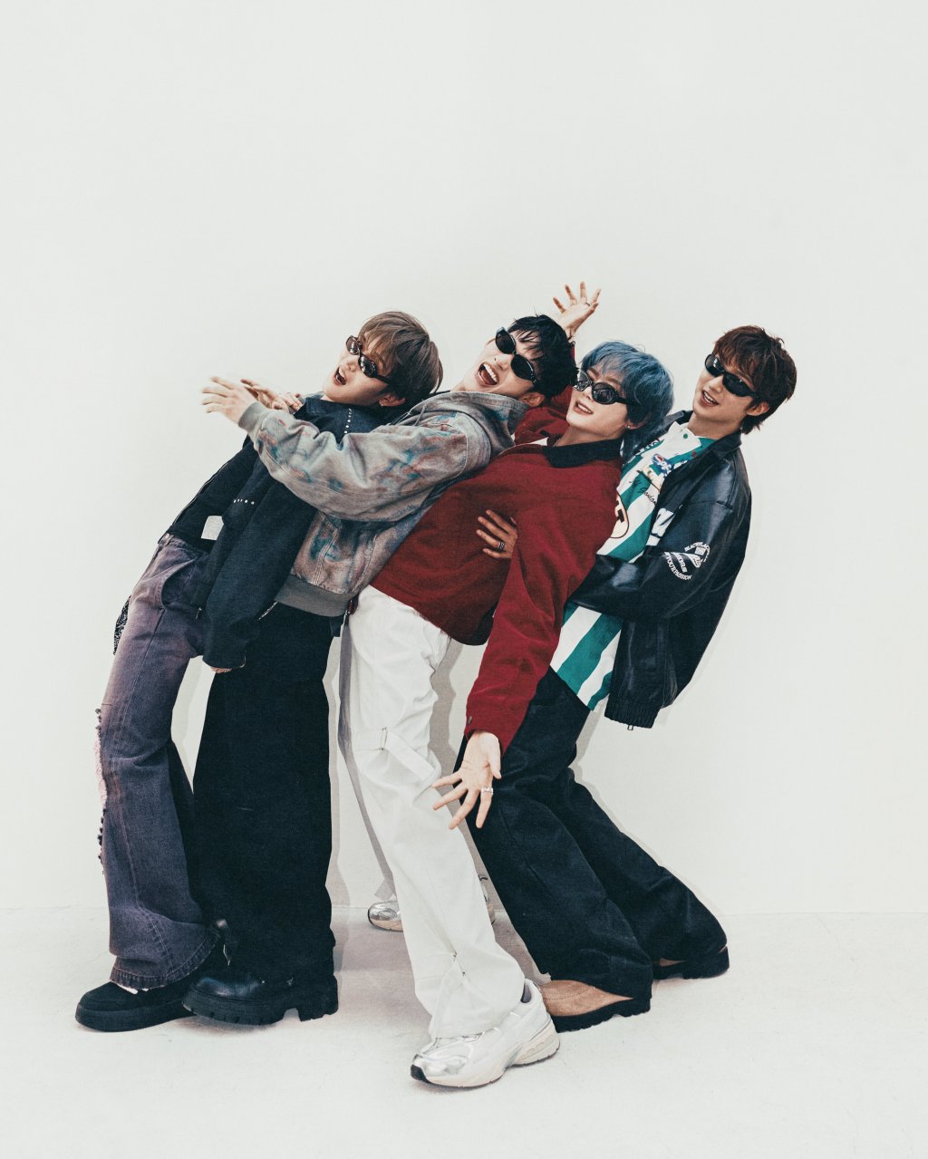 All four members of 1VERSE stand together facing to the left leaning backwards. From left to right, Seok, Nathan, Aito and Kenny are all wearing shades.